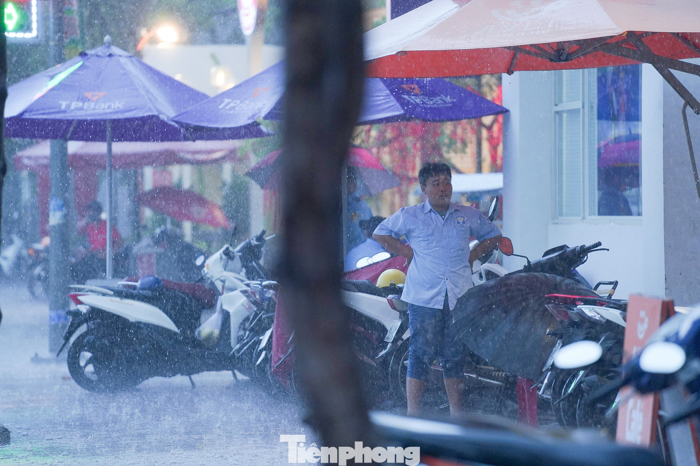 Bảo vệ của một các cơ quan, hàng quán vất vả trông giữ xe khi mưa lớn.