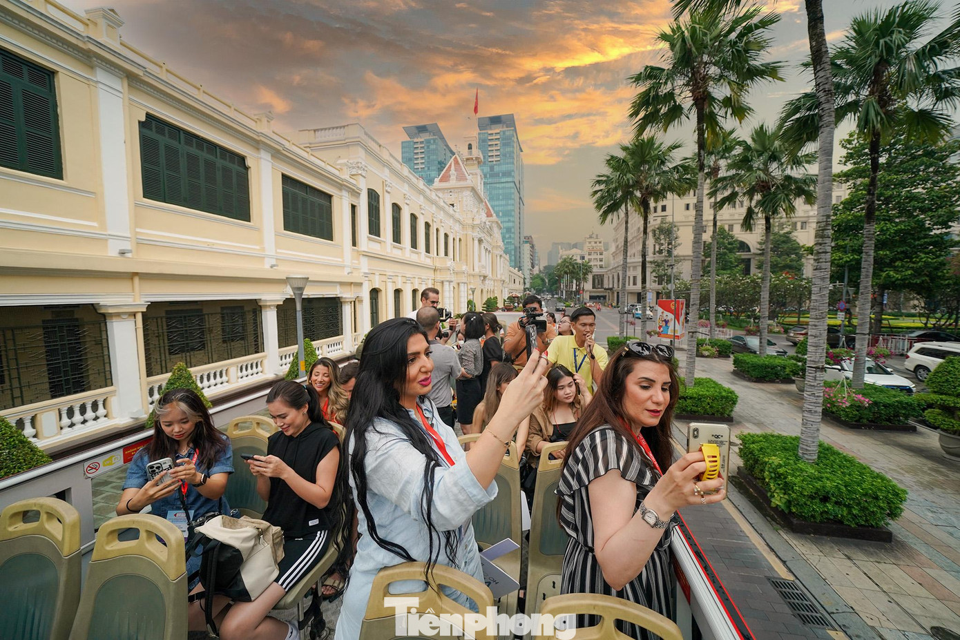 Cô Kafeya Abu Dayeh (áo xanh), đại diện đến từ Jordan thích thú chụp ảnh khi xe buýt đi ngang qua toà nhà UBND TPHCM.