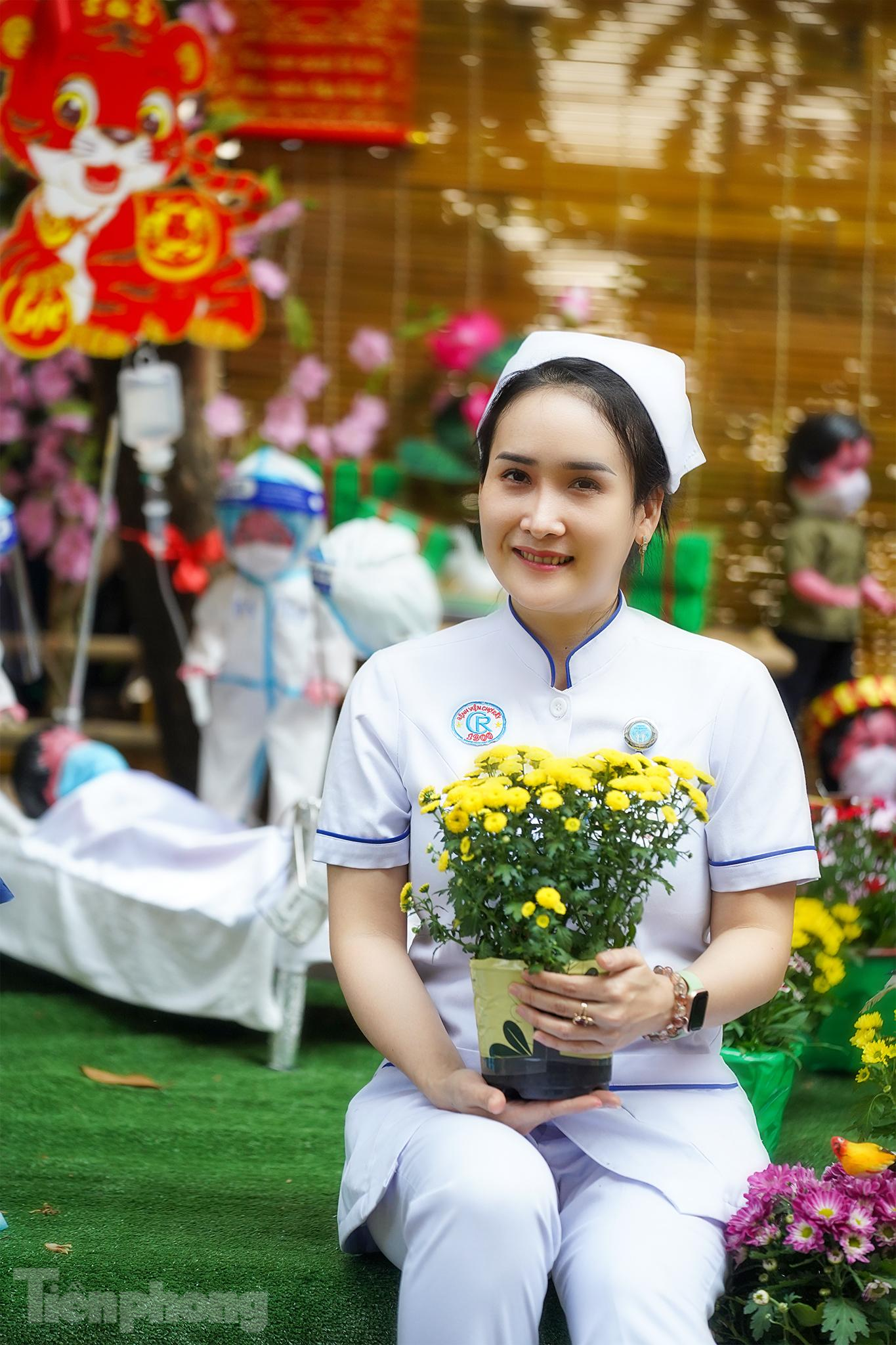 Điều dưỡng Trần Thị Liên tranh thủ vừa xuống ca trực đến đường hoa chụp ảnh với không gian trưng bày gợi nhớ thời điểm TPHCM căng mình chống dịch.