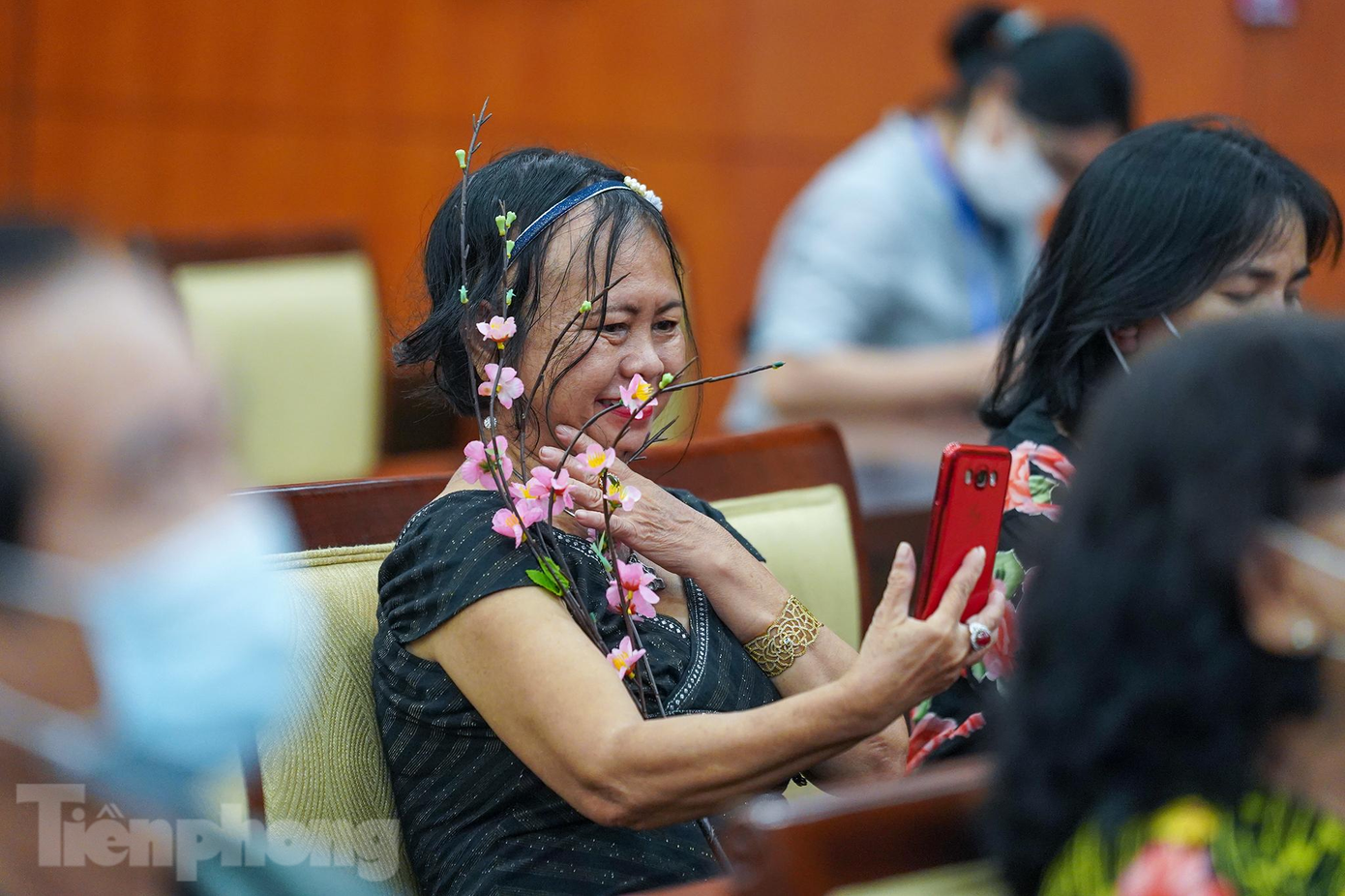 Một kiều bào còn mang cả cành đào vào không gian buổi gặp gỡ để chụp ảnh lưu niệm.