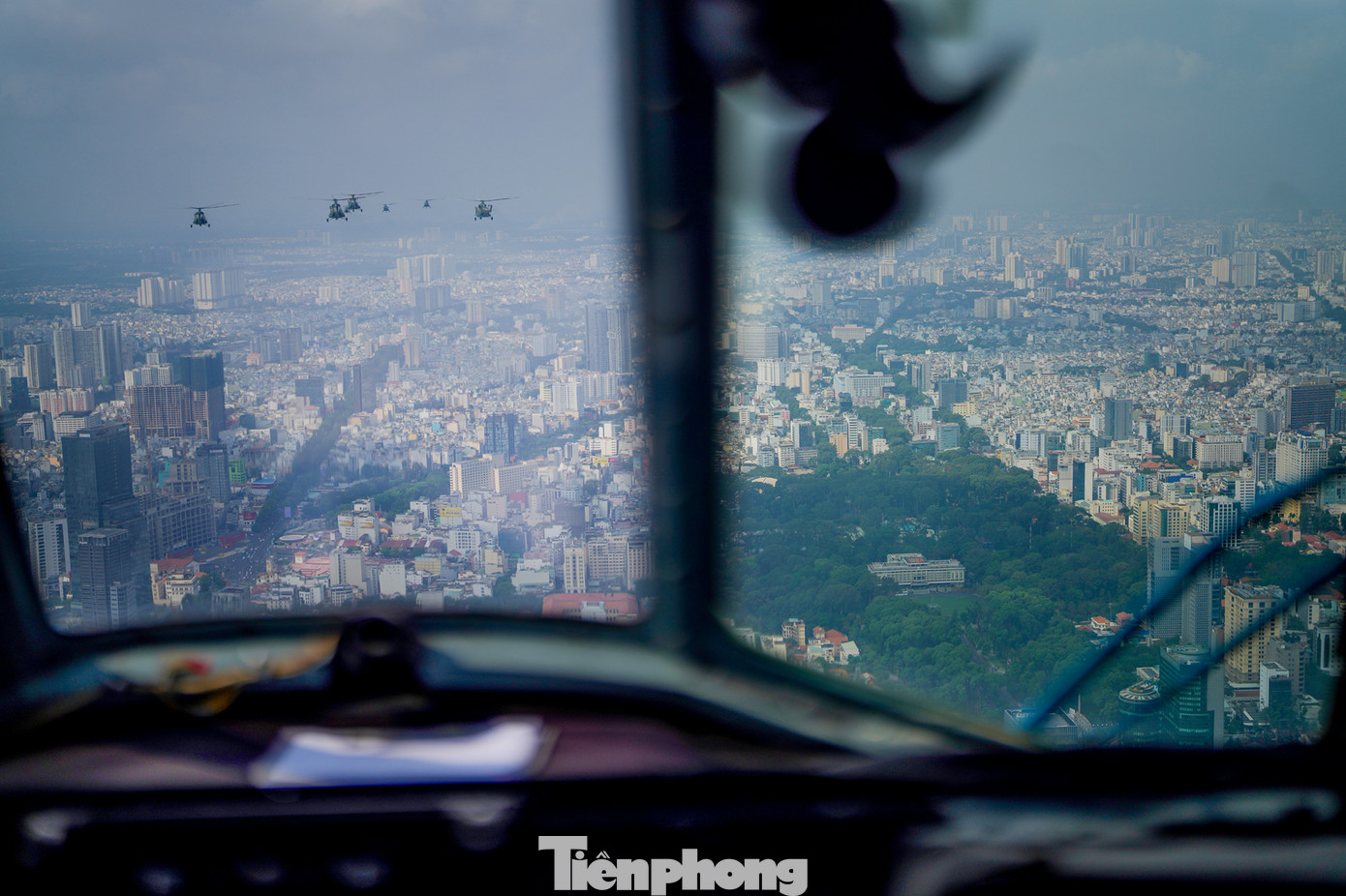 Biên đội trực thăng bay qua Hội trường Thống Nhất (toà nhà nằm giữa khu vực cây xanh).