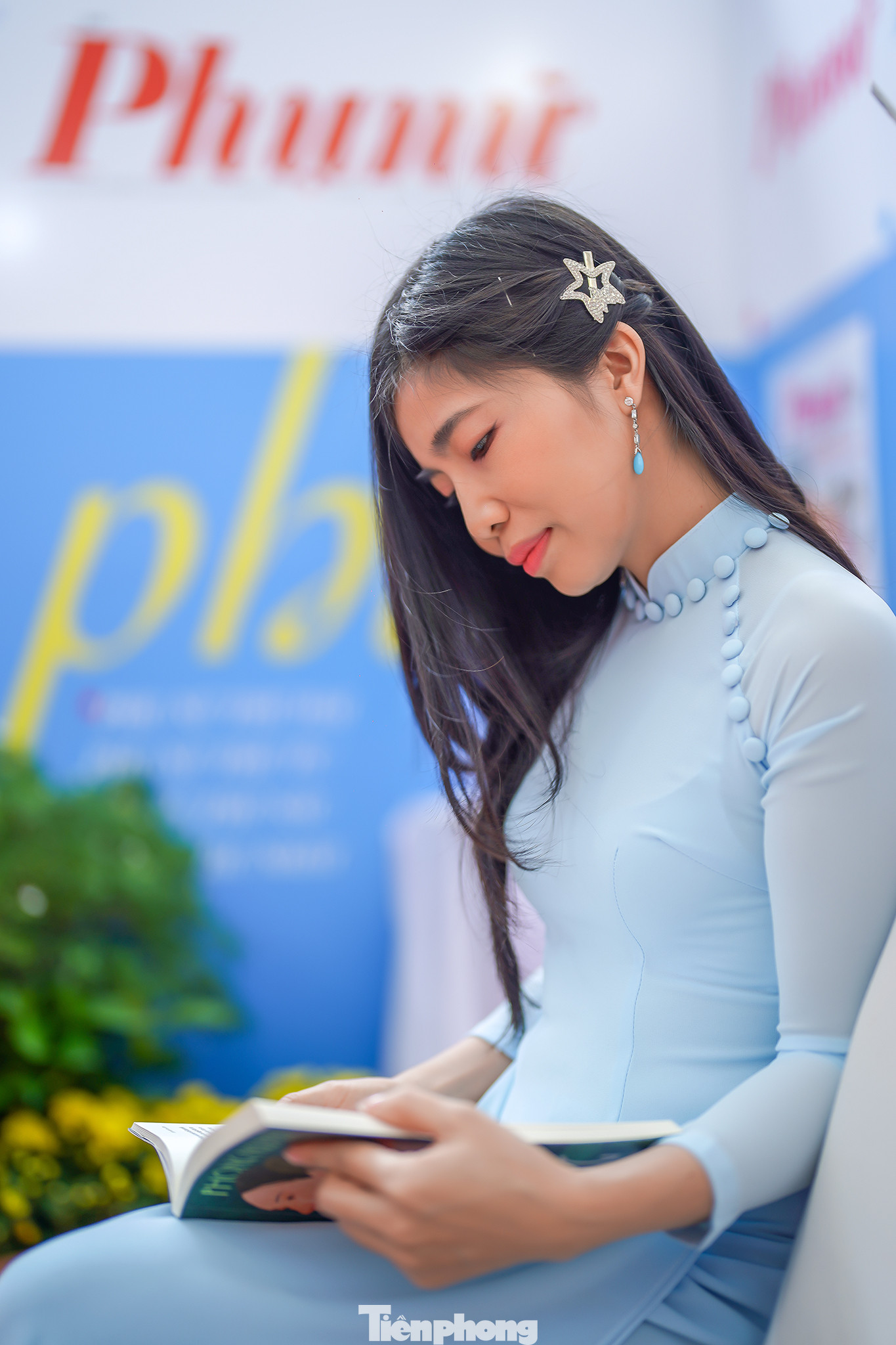 Nhà văn Bùi Tiểu Quyên, ban VH-VN báo Phụ nữ TPHCM trong tà áo dài tại gian trưng bày báo Phụ nữ.