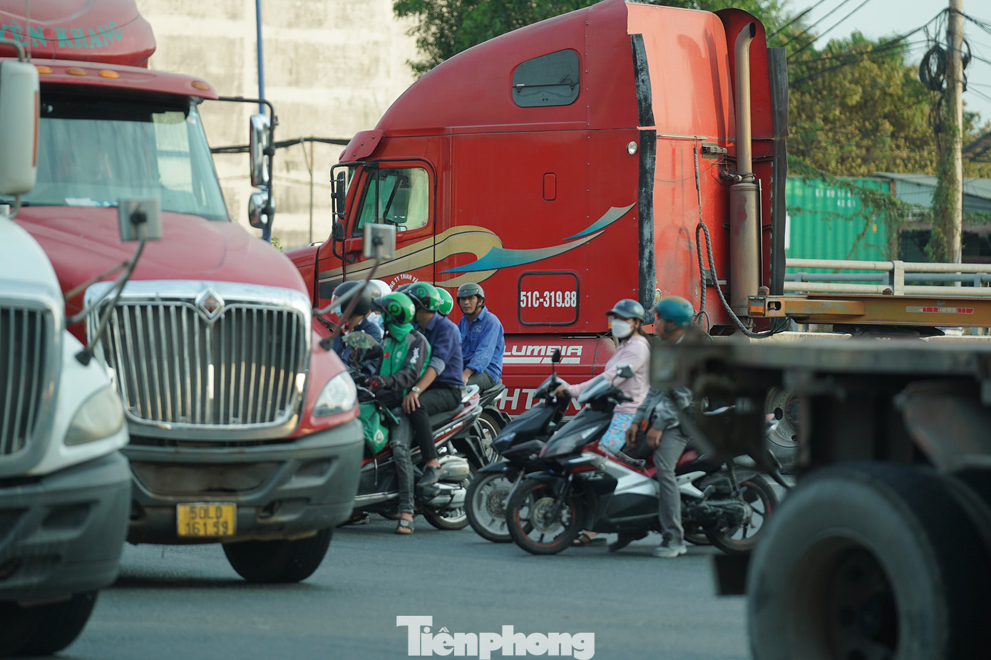 Người đi xe máy lọt thỏm vào những chiếc container, rơ móc...