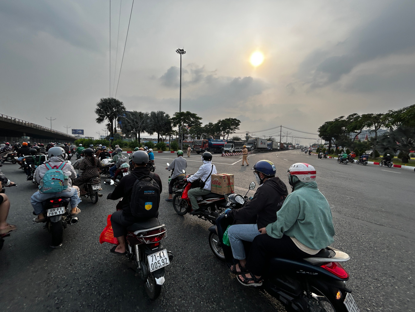 Dòng phương tiện di chuyển dưới sự điều tiết của CSGT tại vòng xoay cầu vượt Nguyễn Văn Linh (quận Bình Tân)