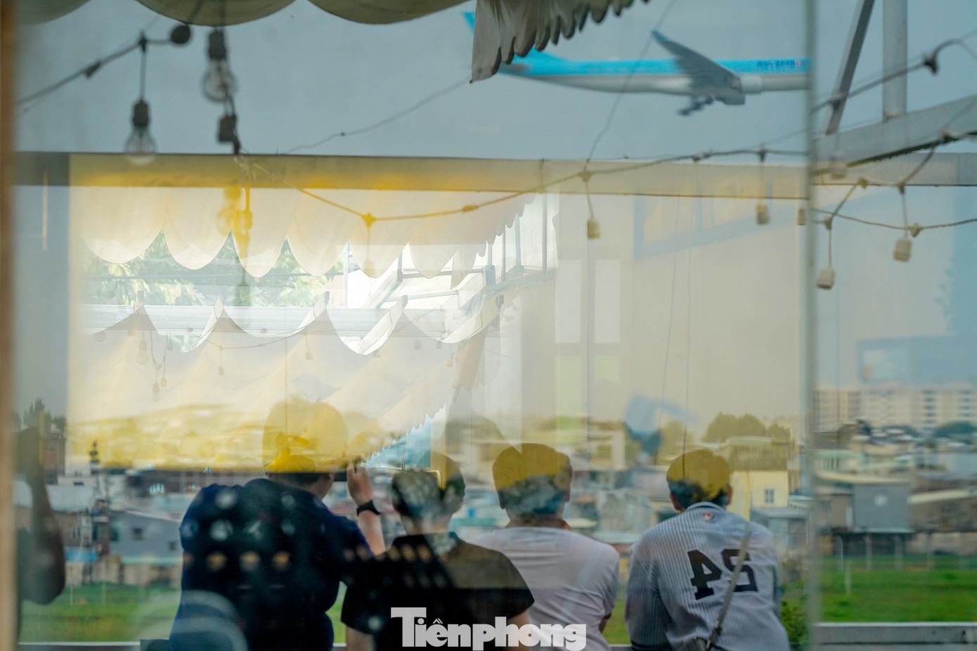 Một nhóm bạn trẻ thích thú xem máy bay của một hãng Hàn Quốc hạ cánh.