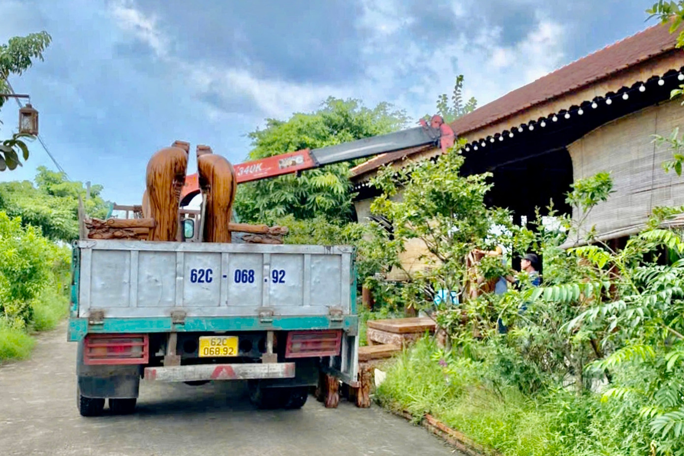 Xe tải cẩu di chuyển đồ gỗ nội thất ra khỏi khu nhà rường trong KDL.