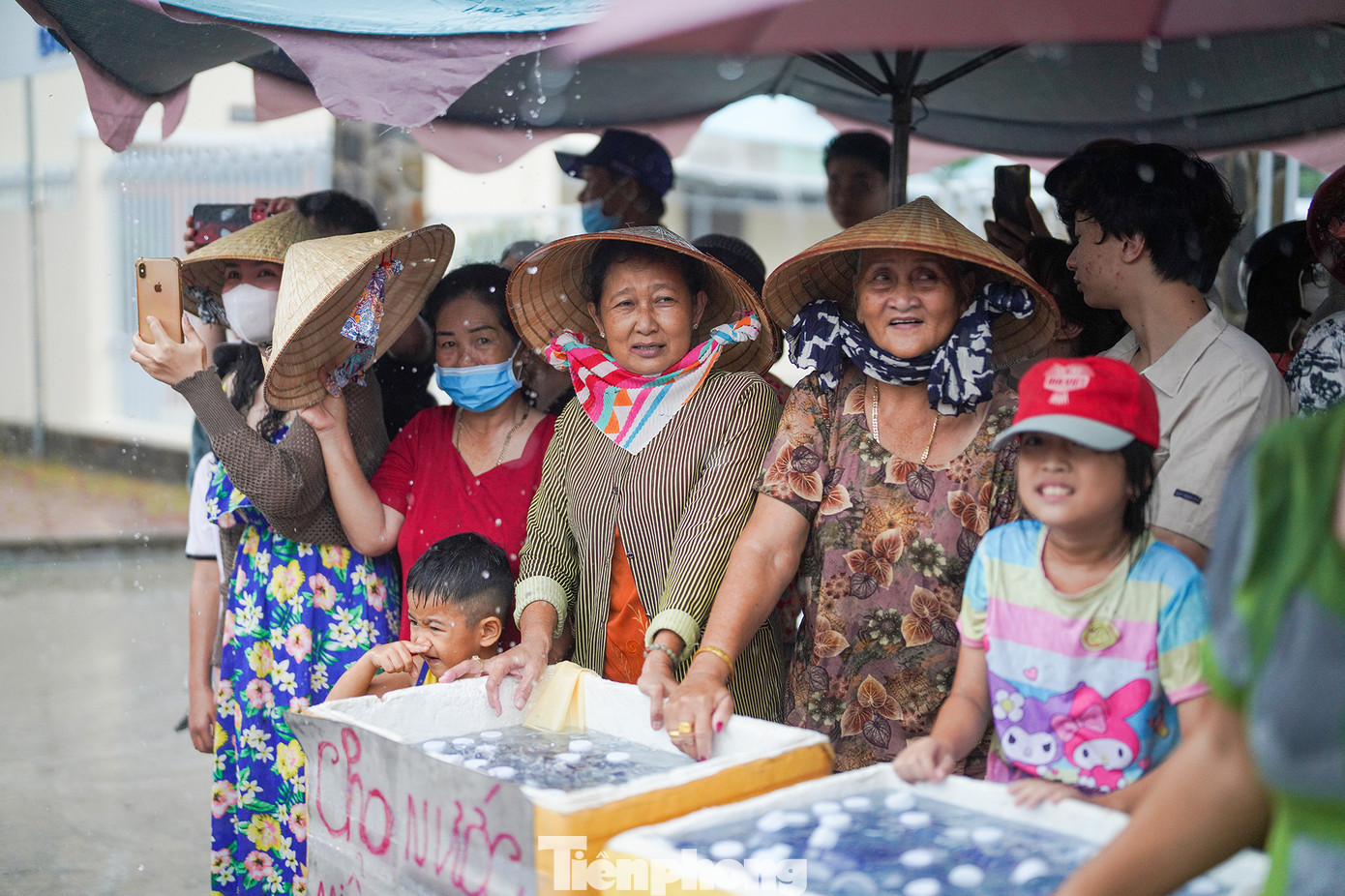 Người dân chuẩn bị nước uống đóng chai phát miễn phí cho du khách. Tuy cơn mưa khá to, ai nấy cũng đều phấn khởi, chào đón nhau bằng những nụ cười. Có thể thấy Nghinh Ông là ngày Tết của bà con vùng biển.