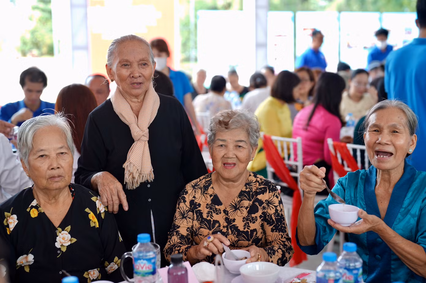 Nữ dân công Nguyễn Thị Khỏi (đứng) đang hỏi thăm sức khoẻ các đồng đội.