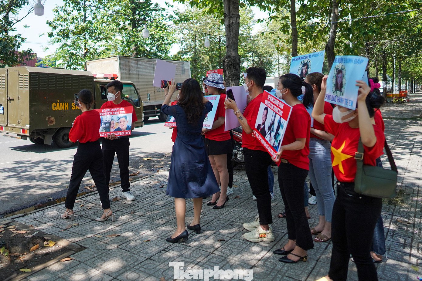 Nhóm người dân giơ cao bảng khi thấy xe chở bị cáo Nguyễn Kim Trung Thái.
