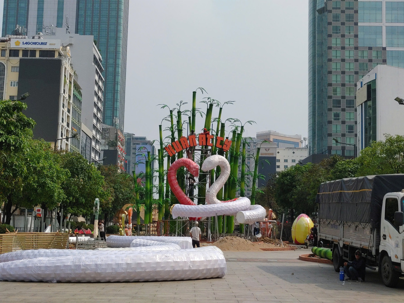 Tại công trường, công nhân tất bật thi công lắp ráp hoàn chỉnh các kết cấu rời, ghép nối tạo hình 2 chú rắn "khủng" tại khu vực cổng chào Đường hoa Tết Ất Tỵ.