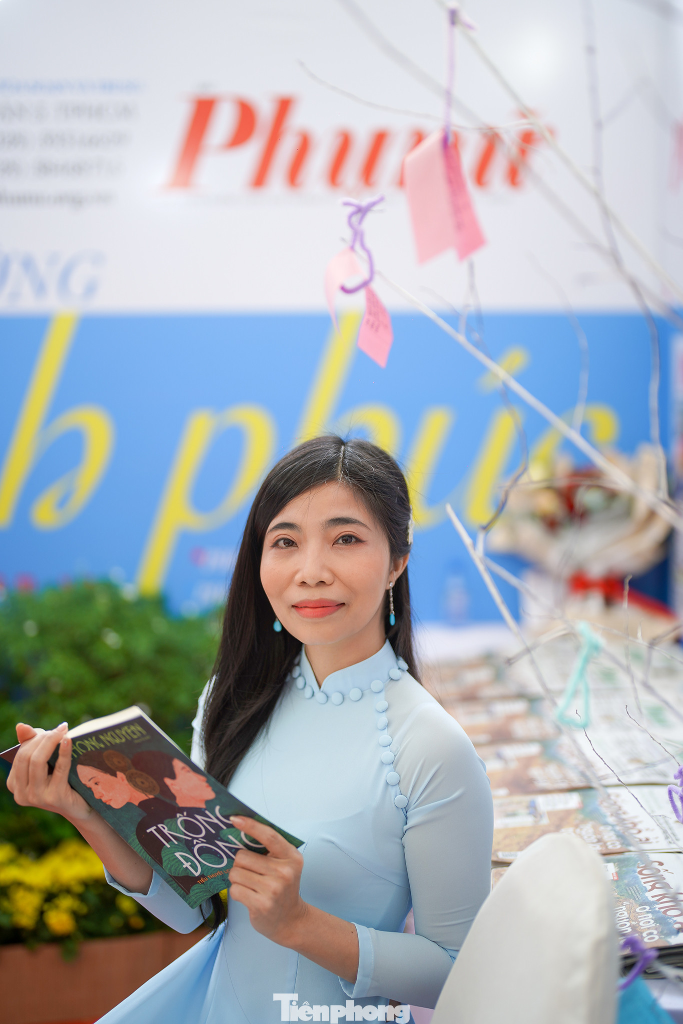 Nhà văn Bùi Tiểu Quyên, ban VH-VN báo Phụ nữ TPHCM trong tà áo dài tại gian trưng bày báo Phụ nữ.