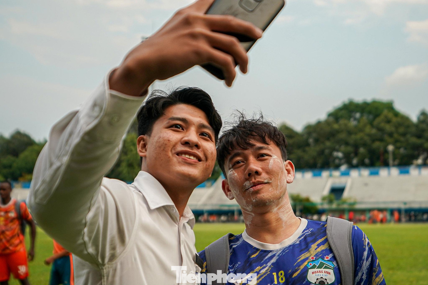 Tiền vệ Minh Vương chụp ảnh cùng người hâm mộ khi vẫn chưa kịp rửa mặt.