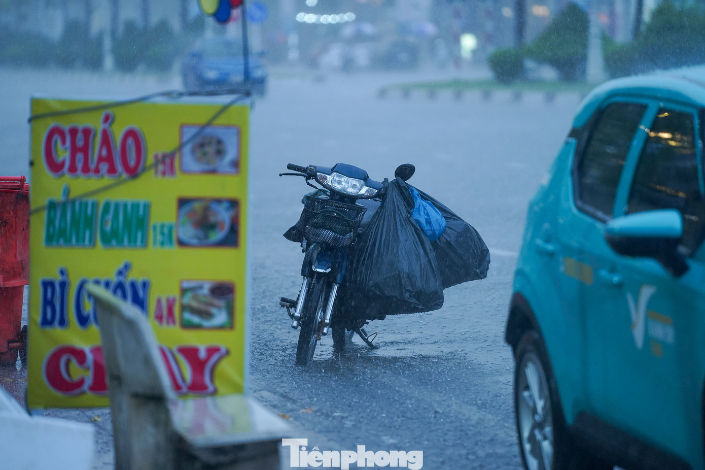 Một người dân dựng vội xe máy, chạy vào trong mái hiên trú mưa.