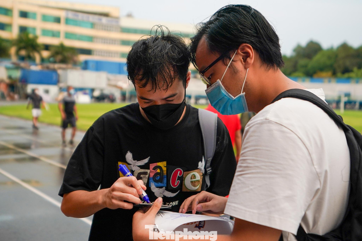 Tiền đạo Nguyễn Văn Toàn ký tặng người hâm mộ sau khi rửa sạch phần bột trắng trên mặt.
