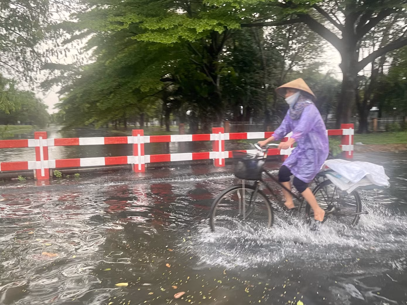 Cơn mưa lớn khiến con kênh nước đen tràn lên mặt đường bốc mùi hôi.