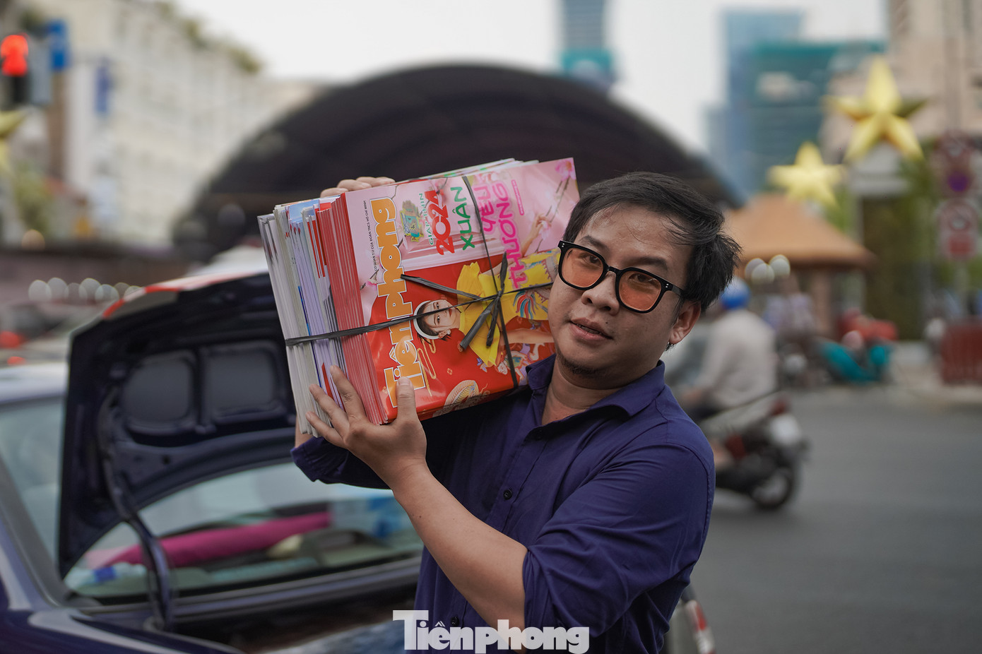 Anh Minh Hoàng, nhân viên hành chính VP Báo Tiền Phong tại TPHCM đang gấp rút chuyển báo Xuân TIền Phong 2024 vào gian hàng.