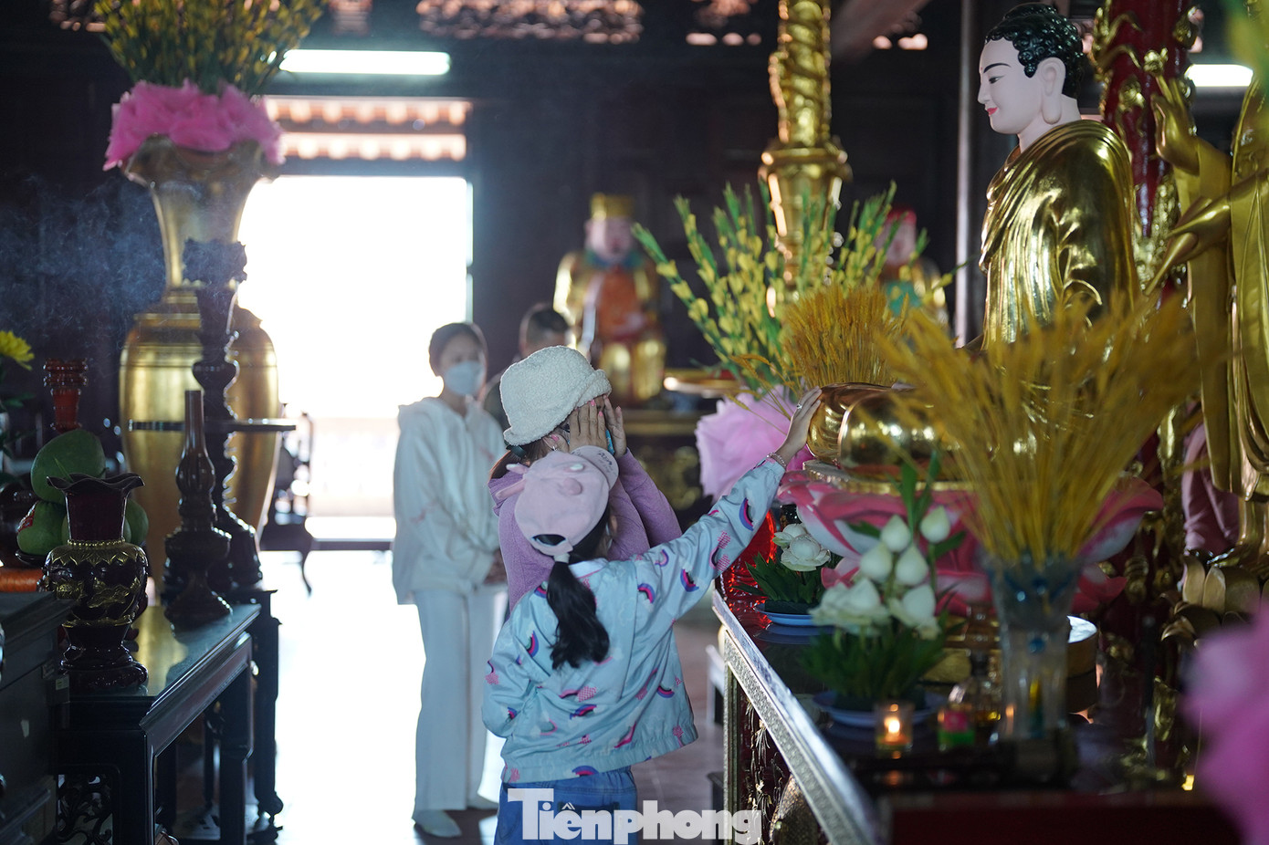 Bên trong chánh điện, nhiều Phật tử dẫn con cháu đến đây sờ tay vào tượng Phật để mong cầu bình an, may mắn.