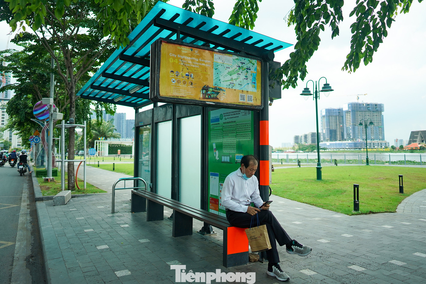 Du khách Hàn Quốc đang núp nắng tại nhà chờ bến xe buýt.