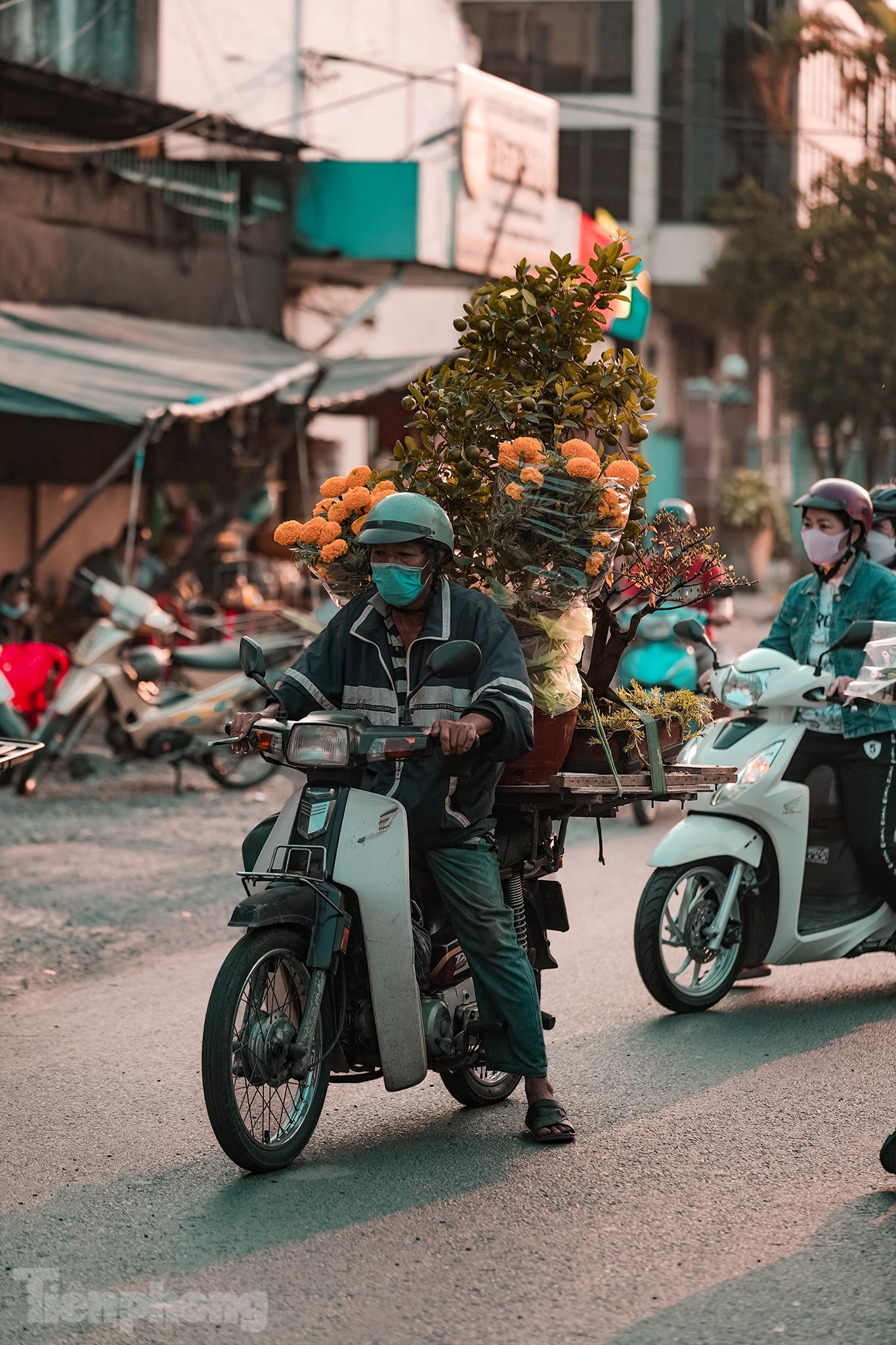 Người chuyển hoa này cho biết năm nay có vẻ ổn hơn, mỗi ngày ông kiếm hơn chục cuốc xe nếu đi gần.