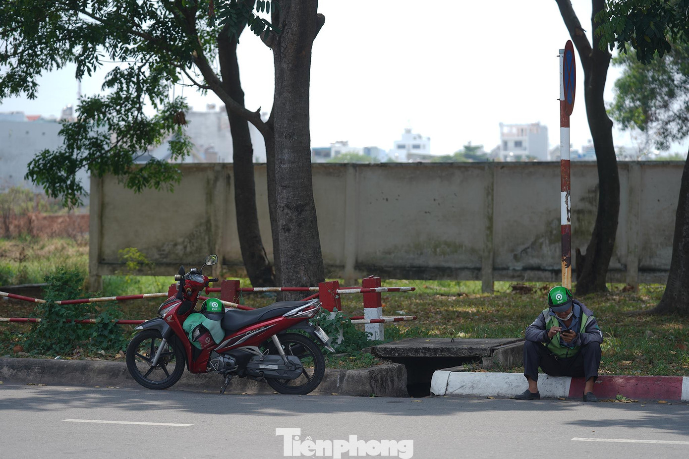 Một bác tài khác nghỉ ngay trên vỉa hè, lướt điện thoại tìm khách. Một bác tài khác nghỉ ngay trên vỉa hè, lướt điện thoại tìm khách.