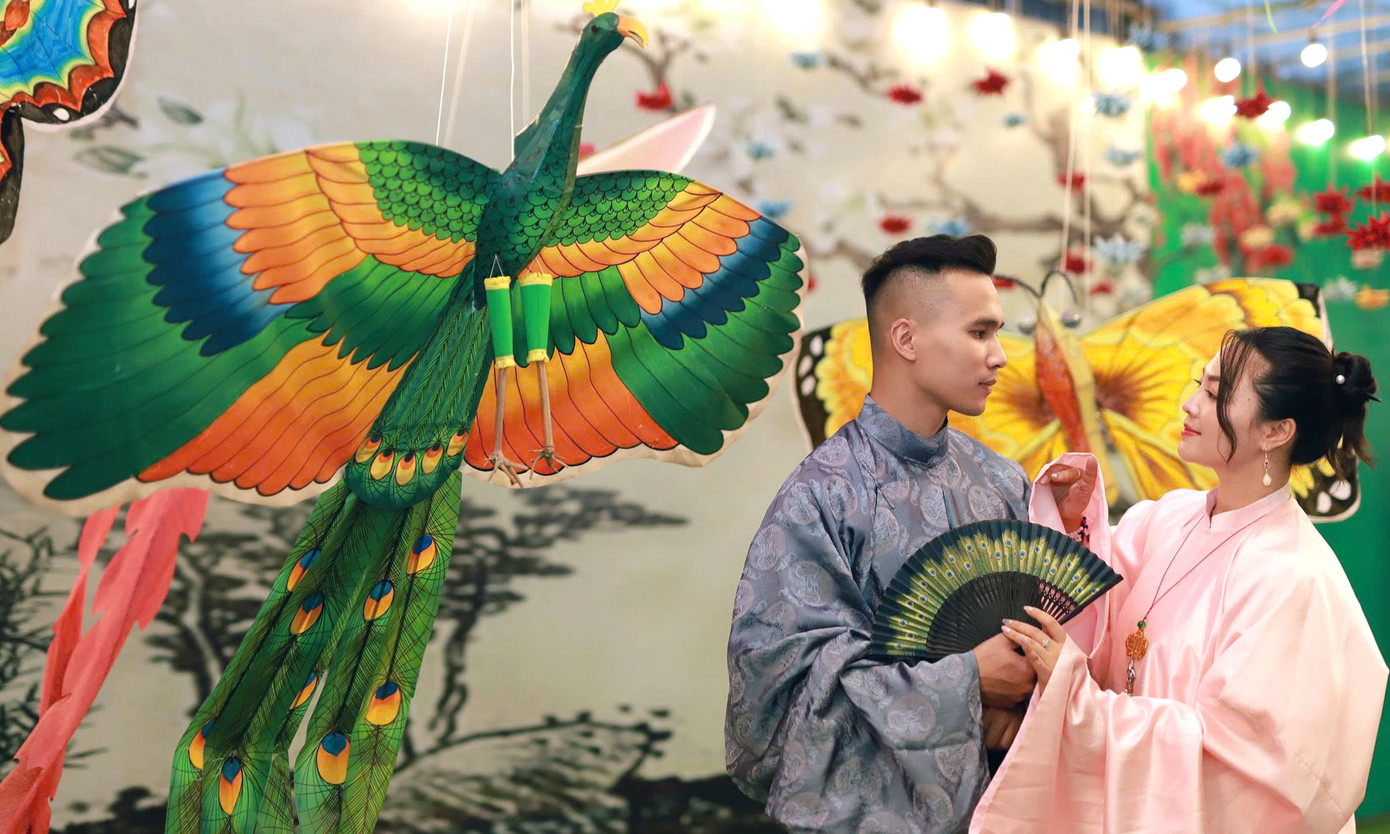 Cùng với những trang phục năng động ngày Hè, nhiều bạn trẻ đã diện mẫu áo dài truyền thống để tạo dáng với không gian diều. Nguyễn Văn Hải (sinh viên ĐHQG Hà Nội) cùng nhóm bạn đã cùng có hành trình trở về tuổi thơ với cánh diều, tiếng sáo vi vu giữa không gian xanh của bầu trời, ruộng đồng; cũng như những trò chơi ô ăn quan, kéo co. “Tôi không chỉ có dịp gặp lại những cánh diều vừa quen thuộc về kiểu dáng vừa mới lạ khi được trang trí bằng những bức tranh dân gian như đàn lợn âm dương, vinh quy bái tổ… Tôi cũng đã chụp ảnh bên những cánh diều này để lưu giữ kỷ niệm”, Hải nói. Ảnh: Đỗ Hưng