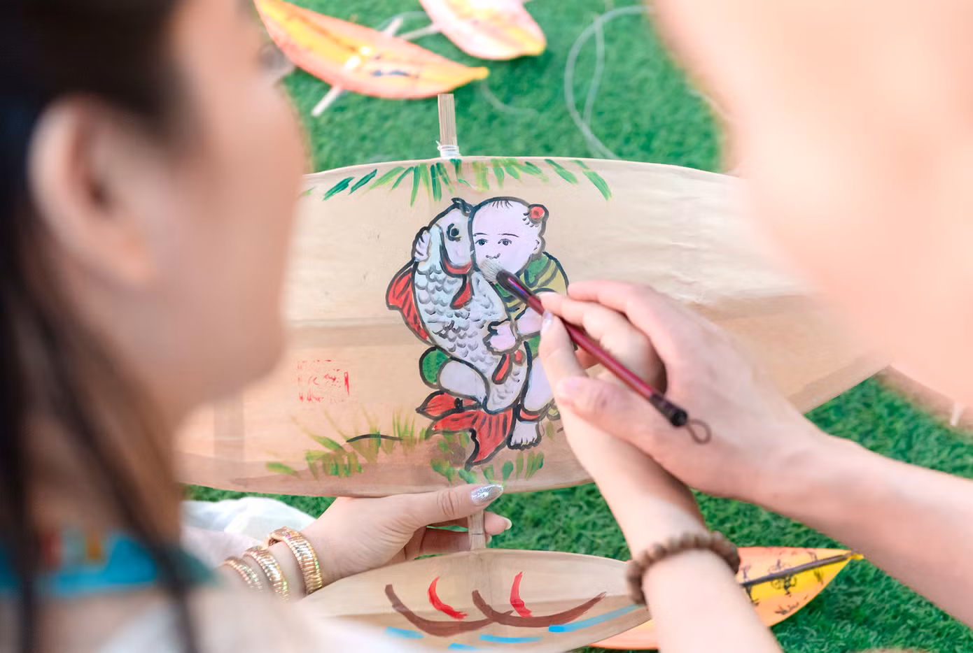 Các bạn trẻ còn có dịp trải nghiệm nhiều trò chơi dân gian như ô ăn quan, nhảy dây, kéo co; workshop trải nghiệm nghệ thuật dân gian; được tự tay thiết kế những chiếc diều tại xưởng vẽ diều sáng tạo, hoặc học cách làm quạt truyền thống từ giấy điệp, kết hợp với màu vẽ được pha chế từ vỏ sò điệp. Ảnh: Đỗ Hưng