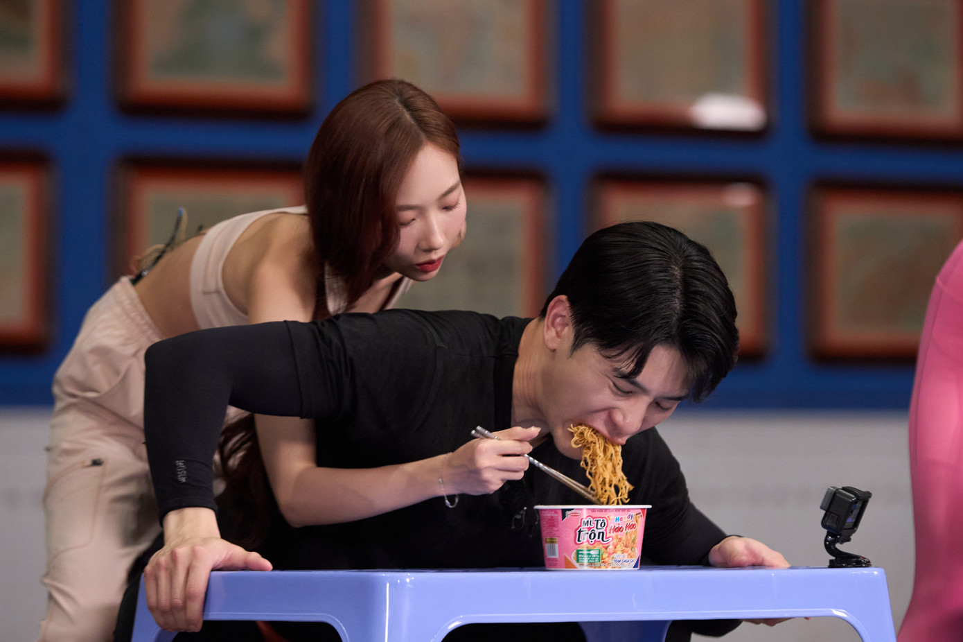 Các người chơi thực hiện thử thách vượt sào, ăn mì, vừa bồng bế người chơi nữ vừa squat...