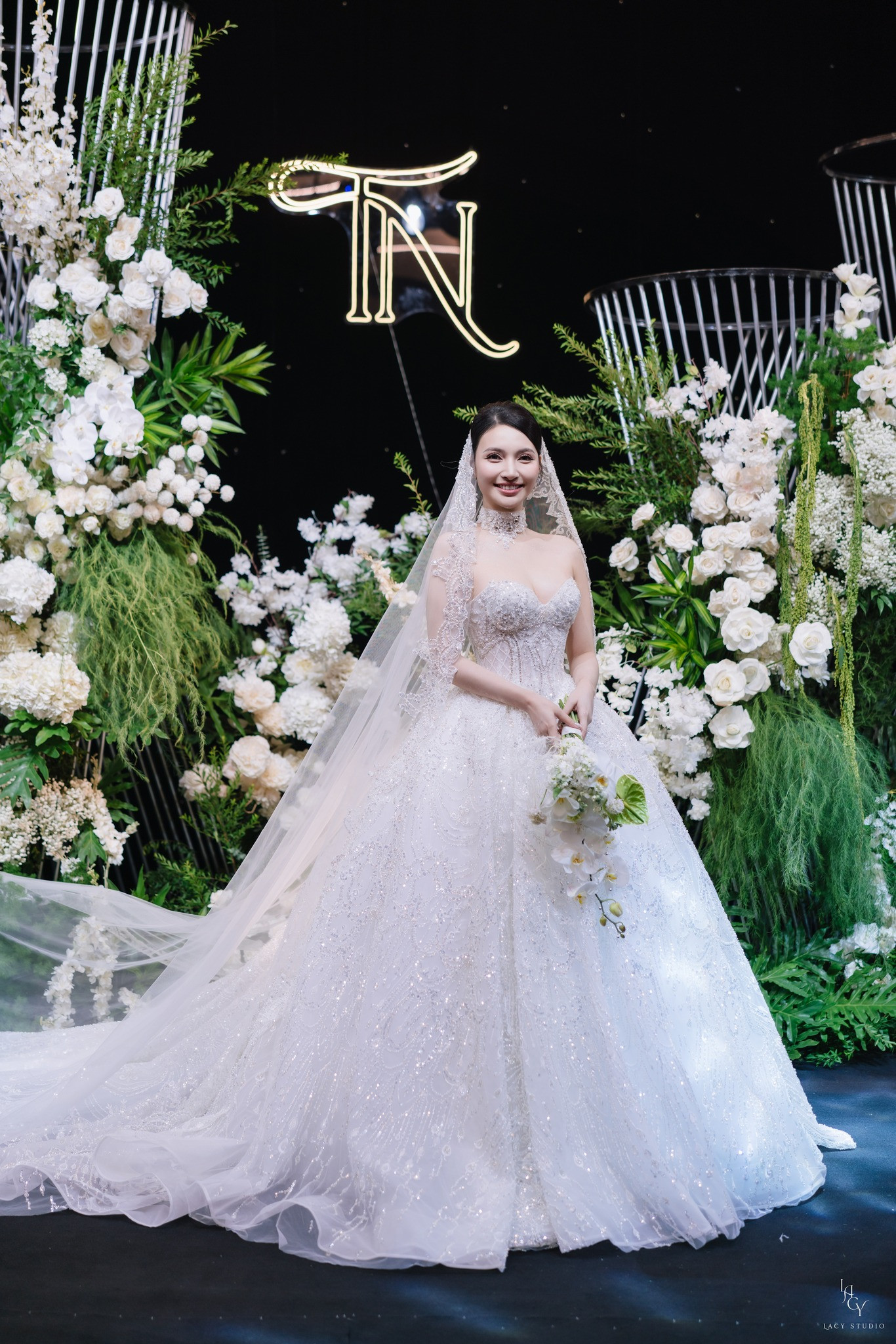 Trong đám cưới, Bích Thủy diện hai mẫu váy trị giá hơn 200 triệu đồng. Mẫu váy Ball Gown với phần tùng váy được nạm đá cùng kỹ thuật cắt laser để tạo độ bồng bềnh. Form váy dựng cấu trúc tôn lên vòng eo thon gọn với thiết kế corset siết eo tinh tế. Phần đính kết từ viền ngực kéo dài xuống tùng váy thu hút. Thiết kế này được thực hiện trong 6 tháng với 15 người thợ thủ công lành nghề và hơn 10.000 viên pha lê được nạm thủ công.