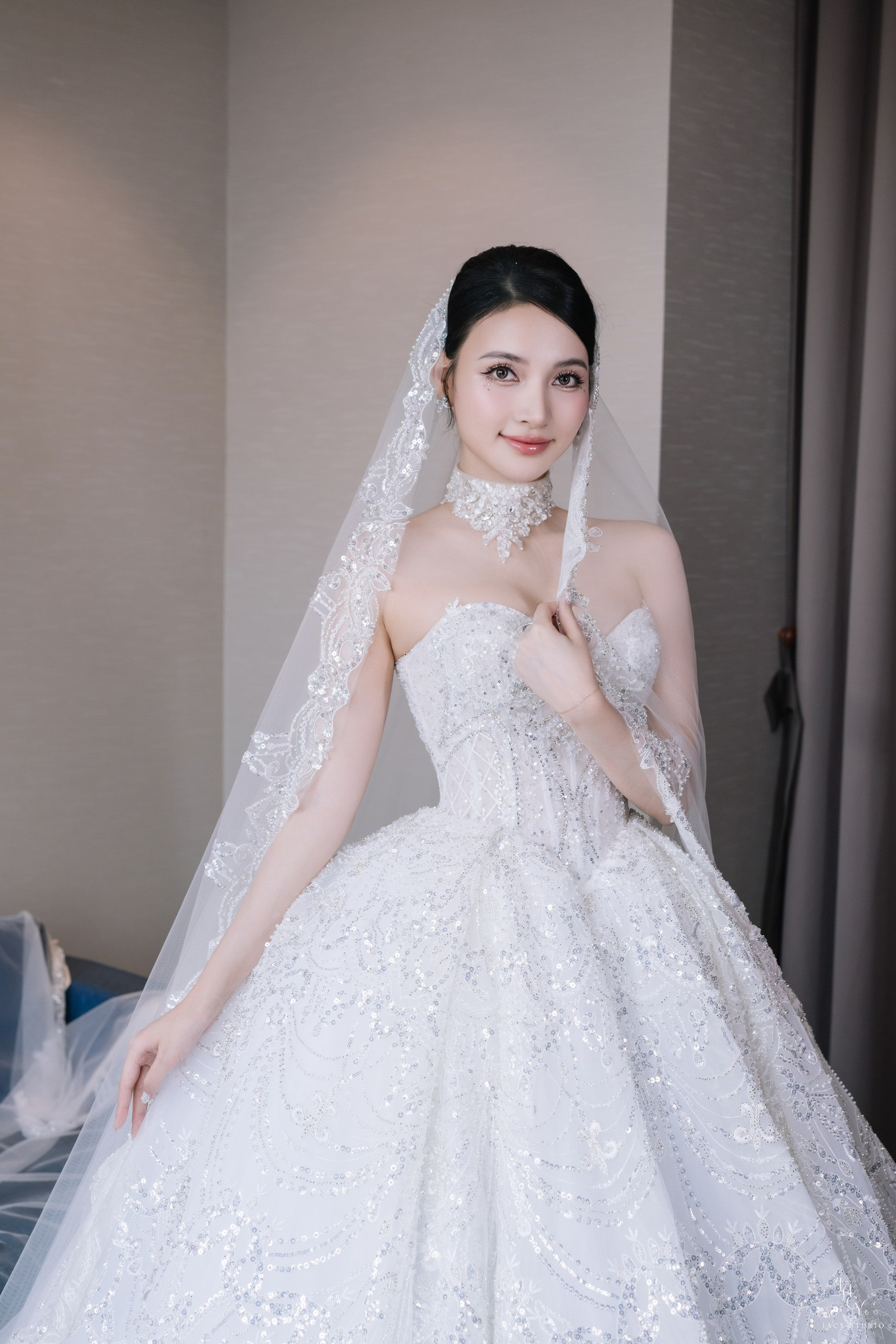 Trong đám cưới, Bích Thủy diện hai mẫu váy trị giá hơn 200 triệu đồng. Mẫu váy Ball Gown với phần tùng váy được nạm đá cùng kỹ thuật cắt laser để tạo độ bồng bềnh. Form váy dựng cấu trúc tôn lên vòng eo thon gọn với thiết kế corset siết eo tinh tế. Phần đính kết từ viền ngực kéo dài xuống tùng váy thu hút. Thiết kế này được thực hiện trong 6 tháng với 15 người thợ thủ công lành nghề và hơn 10.000 viên pha lê được nạm thủ công.