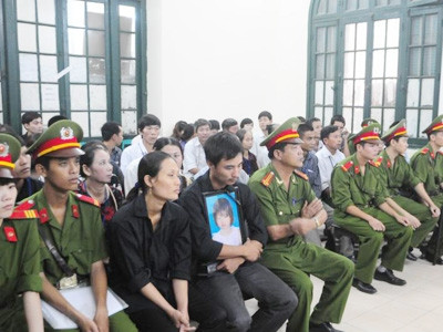 Anh Khuất Văn Hiền ôm chặt di ảnh của con gái cùng vợ mặc bộ đồ đen đau đớn trước cái chết của cô con gái nhỏ. Anh Khuất Văn Hiền ôm chặt di ảnh của con gái cũng vợ mặc bộ đồ đen đau đớn trước cái chết của cô con gái nhỏ