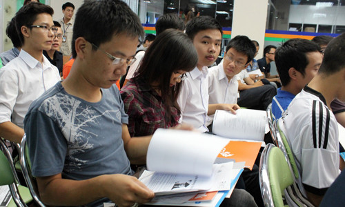 các bạn trẻ chăm chú xem thông tin về các nhà tuyển dụng