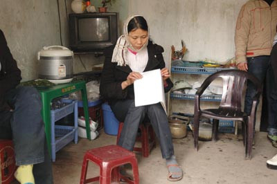 Chị Tựa với lá đơn trình báo mất con . Chị Tựa với lá đơn trình báo mất con