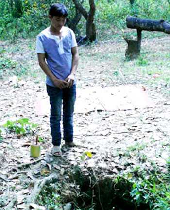 Con trai nạn nhân đau đớn đứng bên cạnh chiếc giếng sâu noi mà mẹ mình bị cha sát hại quẳng xác xuống giếng