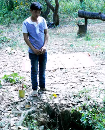 Con trai nạn nhân đau đớn đứng bên cạnh chiếc giếng sâu noi mà mẹ mình bị cha sát hại quẳng xác xuống giếng