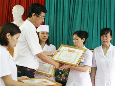 Phó Giám đốc Sở Y tế Hà Nội trao tặng giấy khen kèm 350.000 đồng tiền thưởng cho 3 cá nhân dũng cảm tố cáo tiêu cực tại Bệnh viện Đa khoa Hoài Đức, Hà Nội. Ảnh: Thái Hà.