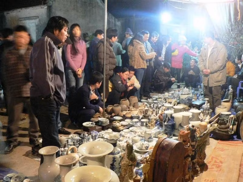 Càng về khuya không khí của chợ Viềng Nam Định càng thêm tấp nập, đông nghịt người (ảnh Nguyễn Huy) Dọc các tuyến hàng khu đồ cổ luôn thu hút khách nhất là giới sưu tầm đồ cổ (ảnh Nguyễn Huy) Một bạn trẻ đang ngã giá chiếc chum được chủ hàng quảng cáo là từ thời... Lê (!?) với giá 1,8 triệu đồng (ảnh Nguyễn Huy). Nông cụ là thứ không thể thiếu của chợ Viềng (ảnh Nguyễn Huy). Đồ Đồng Nam Giang (Nam Trực - Nam Định) được bày bán la liệt, giá thấp nhất năm nay lên đến 300.000 đồng/món (ảnh Nguyễn Huy) Đôi bạn trẻ chăm chú xem quẻ đầu năm vừa xin được ở Chùa Đại Bi (ảnh Nguyễn Huy) Theo cách lý giải của các nhà nghiên cứu văn hóa dân gian, bò cùng loài với hươu, mà trong tiếng Hán Việt hươu được gọi là lộc nên thịt bò là thứ không thể thiếu của chợ Viềng. Năm nay, thịt bò đắt đỏ lên đến 140 - 160.000 đồng/1 kg, nhưng không ít người mua vì để cầu mong tấn lộc, tấn tài (ảnh Nguyễn Huy) Đốt đèn tìm cây đúng với nguyên bản chợ Viềng xưa (ảnh Nguyễn Huy)