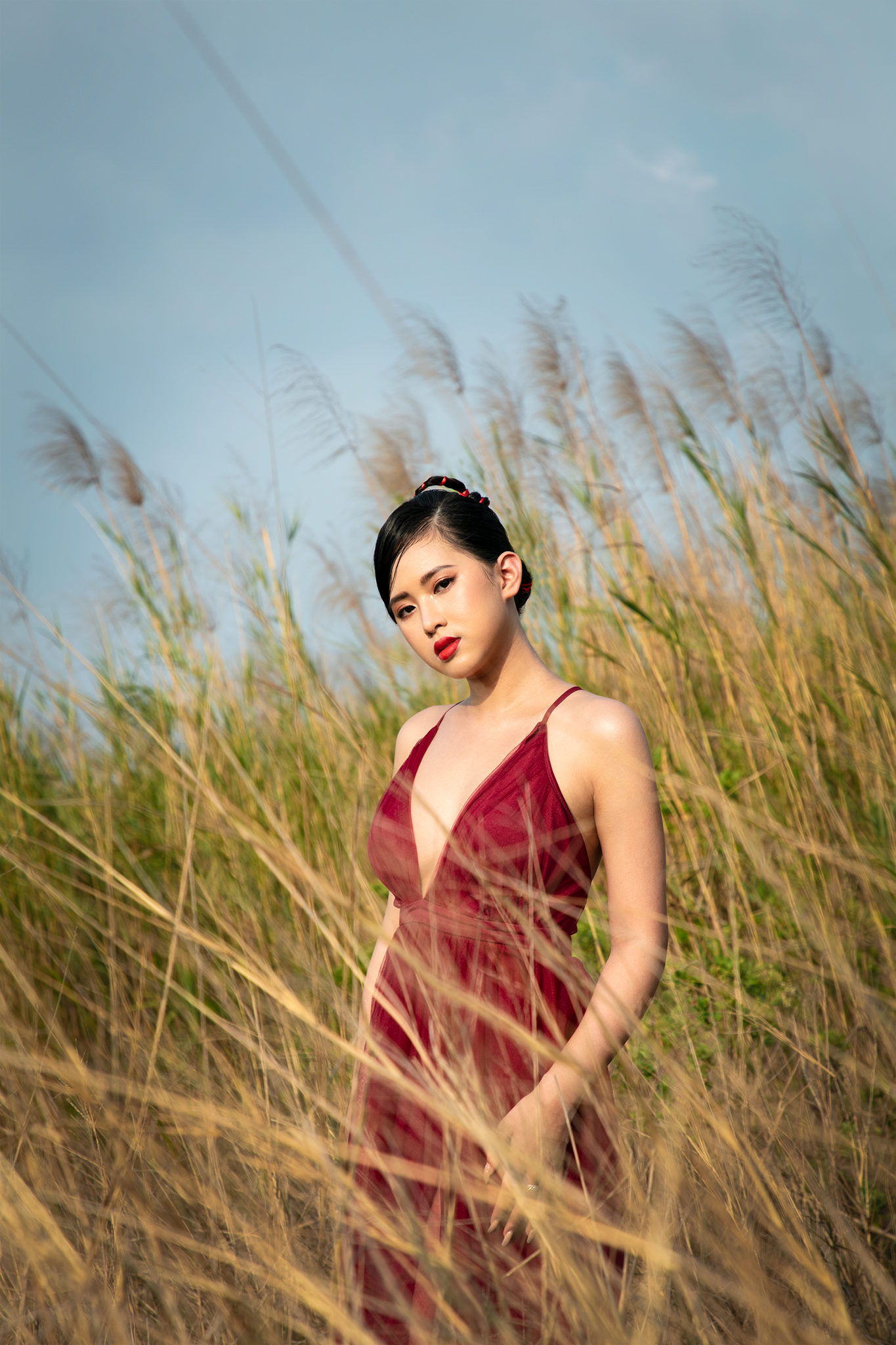 Mới đây, người đẹp Phù Bảo Nghi ngẫu hứng thực hiện bộ ảnh ở cánh đồng lau. Cô nàng diện váy hai dây đỏ rực khoe vòng một siêu gợi cảm.