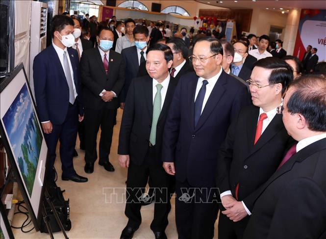 Đồng chí Võ Văn Thưởng, Ủy viên Bộ Chính trị, Thường trực Ban Bí thư cùng đại biểu xem các bức ảnh giới thiệu thành tựu phát triển kinh tế của Việt Nam do phóng viên TTXVN thực hiện. Ảnh: Văn Điệp/TTXVN