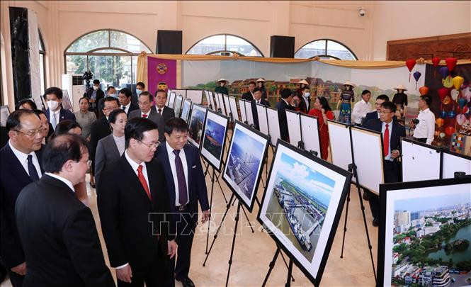 Đồng chí Võ Văn Thưởng, Ủy viên Bộ Chính trị, Thường trực Ban Bí thư cùng đại biểu xem các bức ảnh giới thiệu thành tựu phát triển kinh tế của Việt Nam do phóng viên TTXVN thực hiện. Ảnh: Văn Điệp/TTXVN