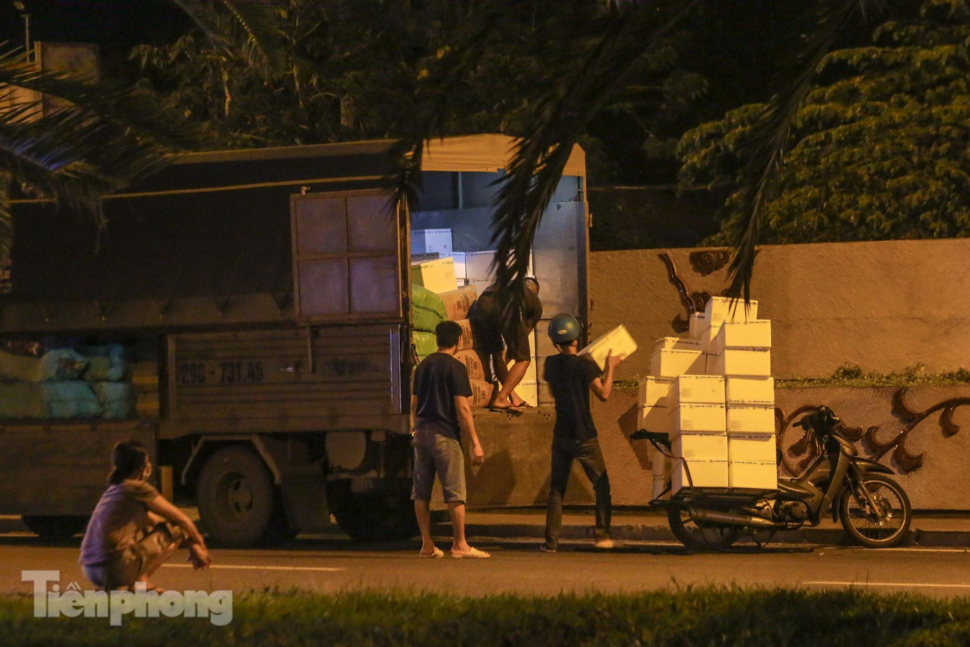 Một xe tải đỗ cách cổng chợ Long Biên 500m trên đường Yên Phụ để dỡ hàng hóa chuyển cho các xe máy.