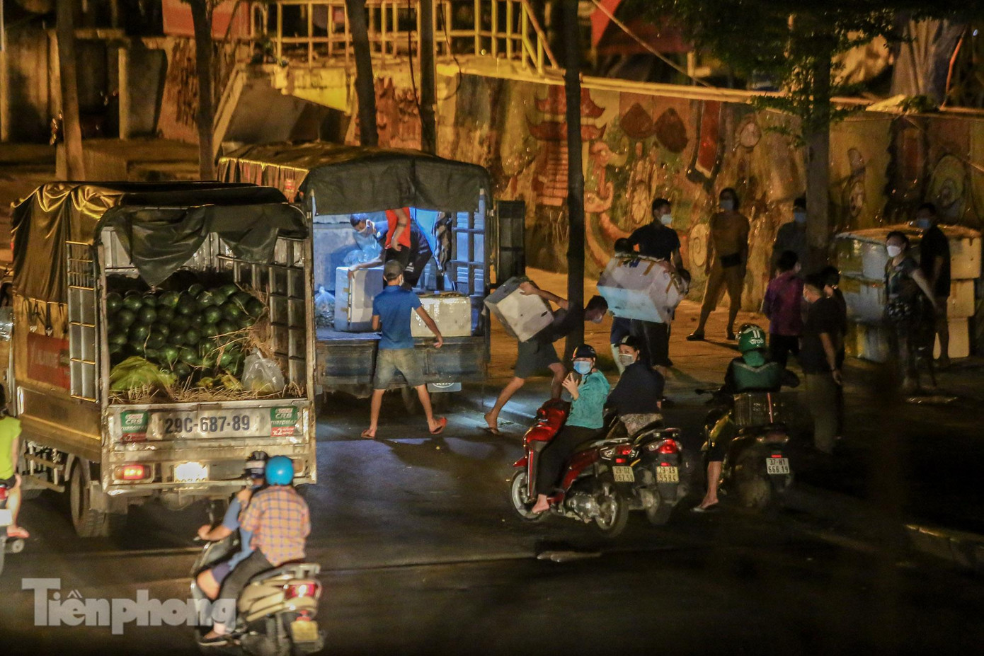 Việc dỡ hàng diễn ra ngay tại vỉa hè bên ngoài cổng chợ Long Biên.