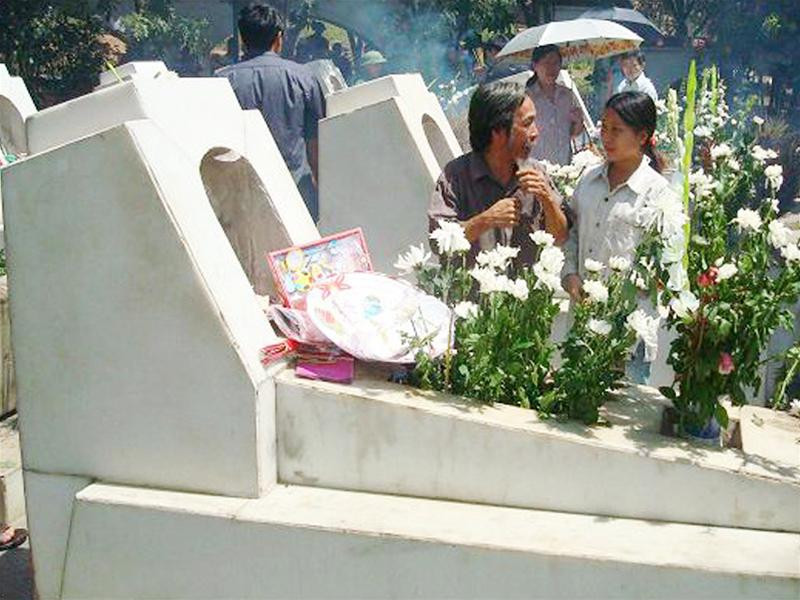 Ông Chương đang nói với con trước mộ 10 nữ TNXP Ngã Ba Đồng Lộc