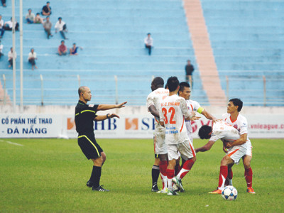 Các cầu thủ XMXT Sài Gòn ngăn cản Việt Cường xông tới trọng tài Nguyễn Văn Kiên. Ảnh: Hà Ngọc