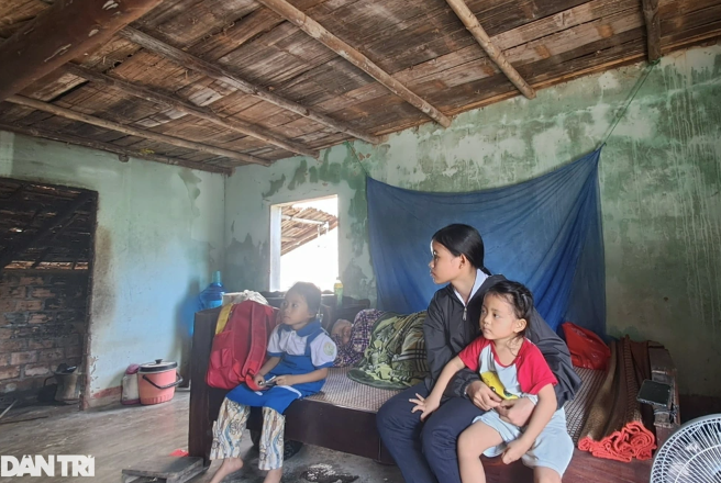 Em Phan Thị Ca cùng 2 em gái nhỏ ngồi bên mẹ bệnh nặng nhưng không có tiền đi bệnh viện chữa trị (Ảnh: Doãn Công).