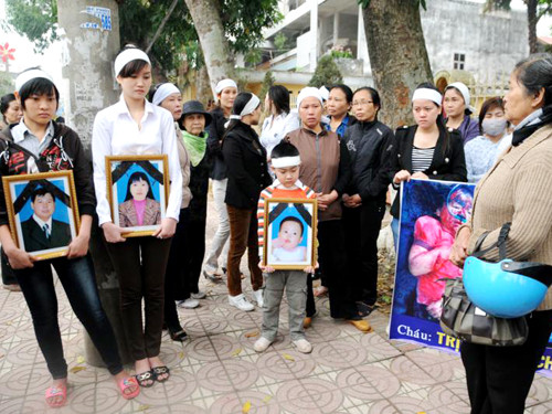 Gia đình nạn nhân ôm theo di ảnh đứng trước cổng tòa án