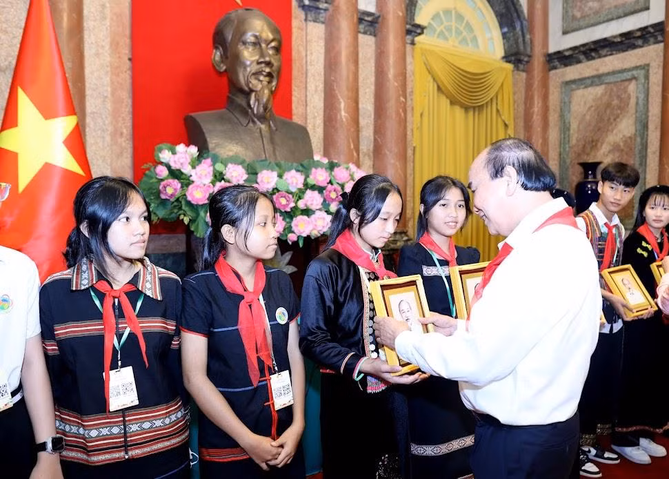 Chủ tịch nước Nguyễn Xuân Phúc tặng quà cho các cháu thiếu nhi tại buổi gặp mặt. Ảnh: Như Ý