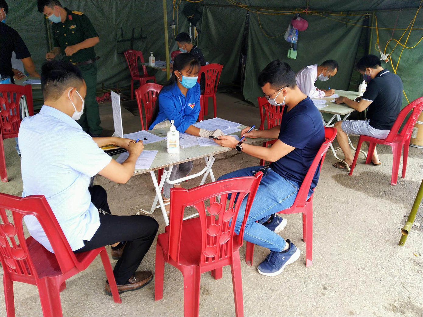 Đoàn viên thanh niên hướng dẫn người khai báo y tế tại chốt kiểm soát dịch. Ảnh: TĐTN