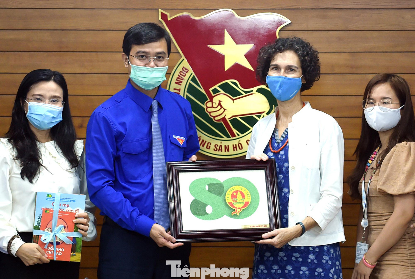 Anh Bùi Quang Huy tặng quà lưu niệm biểu trưng kỷ niệm 80 năm Ngày thành lập Đội TNTP Hồ Chí Minh tới bà Lesley Miller. Ảnh: Xuân Tùng