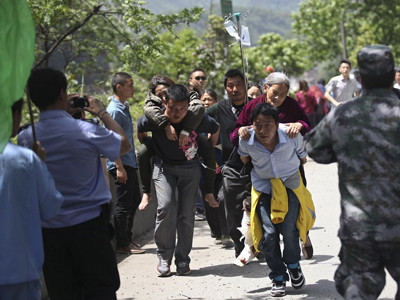 Người dân thẫn thờ nhìn ngôi nhà đổ nát của mình. Ảnh: Reuters