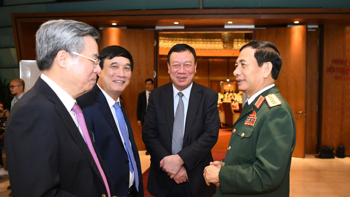 Các đại biểu tham dự phiên khai mạc trao đổi bên lề kỳ họp. Ảnh: Như Ý